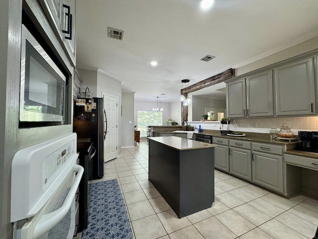 15590 S Fm 92, Spurger, TX 77660 - kitchen with gray cabinetry, ornamental molding, a peninsula, a kitchen island, and freestanding refrigerator