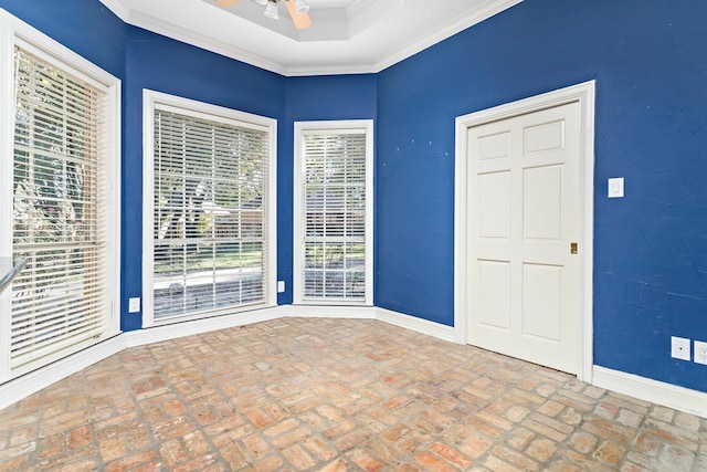 unfurnished room with a raised ceiling and crown molding