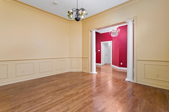 empty room with hardwood / wood-style floors, crown molding, and an inviting chandelier