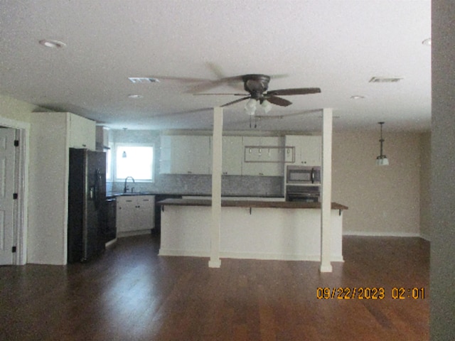 kitchen featuring white cabinets, a kitchen bar, kitchen peninsula, and black appliances