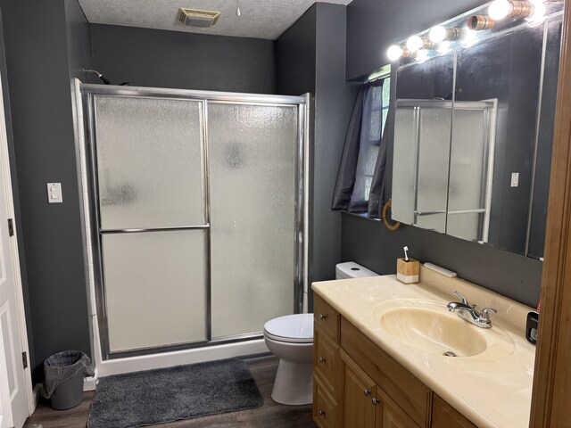 6358 Nick Ave, Port Arthur, TX 77640 - bathroom featuring toilet, wood finished floors, a shower stall, vanity, and a textured ceiling
