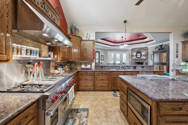 2014 Fish Lk, Kountze, TX 77625 - kitchen featuring ceiling fan, under cabinet range hood, brown cabinets, and stainless steel appliances