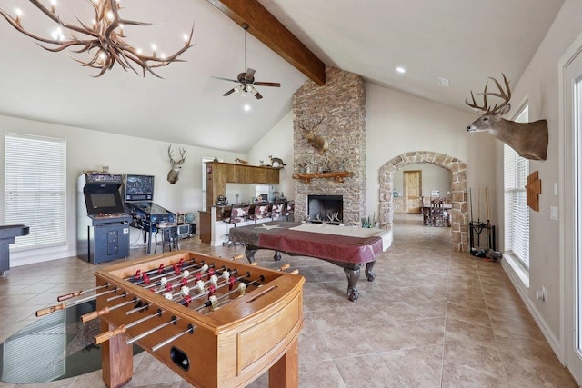 2014 Fish Lk, Kountze, TX 77625 - rec room featuring arched walkways, a fireplace, ceiling fan with notable chandelier, vaulted ceiling with beams, and light tile patterned flooring
