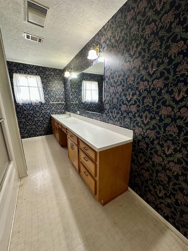 full bath with tile patterned floors, visible vents, a textured ceiling, and wallpapered walls