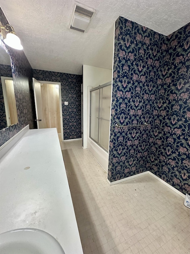 full bathroom with a textured ceiling, vanity, visible vents, tile patterned floors, and wallpapered walls