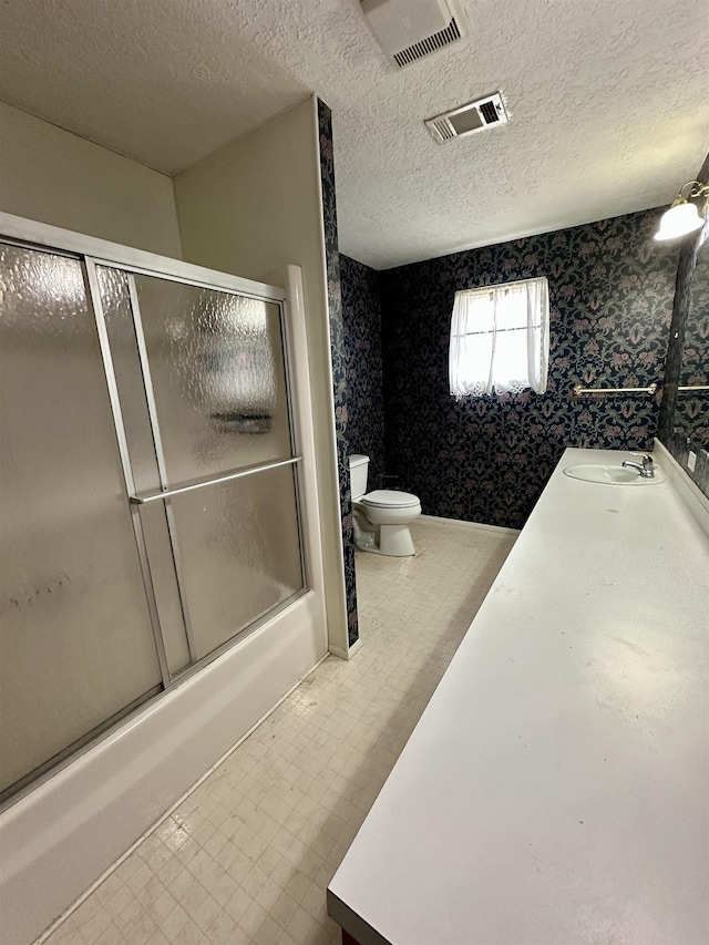 bathroom featuring visible vents, vanity, toilet, and wallpapered walls