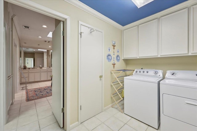 6125 Pinkstaff Ln, Beaumont, TX 77706 - washroom featuring washing machine and clothes dryer, cabinet space, light tile patterned floors, ornamental molding, and baseboards