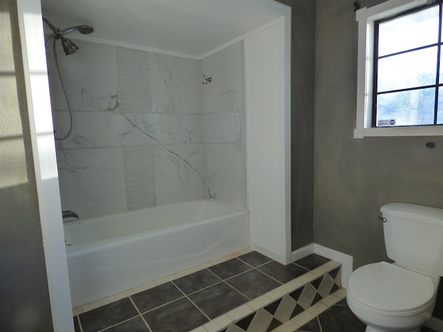 bathroom featuring tile patterned flooring, bathing tub / shower combination, and toilet