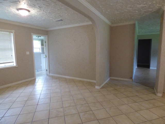 unfurnished room with light tile patterned flooring, a textured ceiling, and ornamental molding