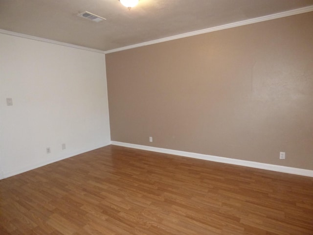 spare room featuring hardwood / wood-style flooring and crown molding