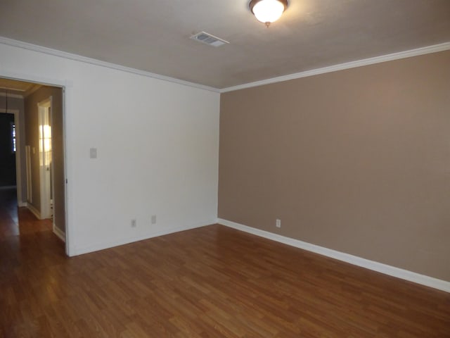 spare room featuring dark hardwood / wood-style floors and crown molding