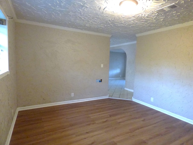 unfurnished room with crown molding, wood-type flooring, and a textured ceiling