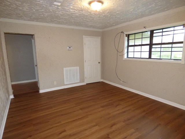 unfurnished room featuring a textured ceiling, crown molding, and dark wood-type flooring