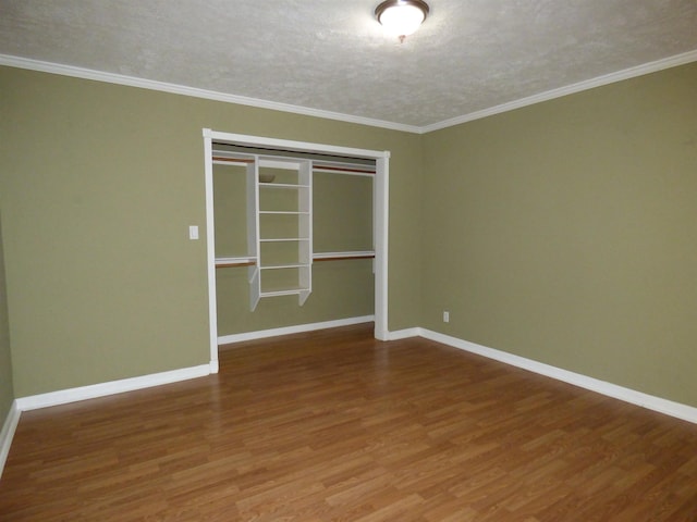 empty room with crown molding, wood-type flooring, and a textured ceiling