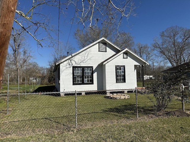 bungalow-style home featuring a front lawn and fence