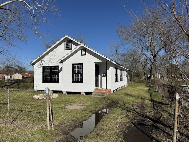 view of front facade with a front lawn and fence