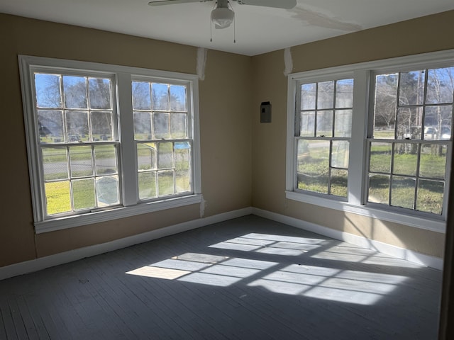 unfurnished room featuring baseboards, ceiling fan, and dark wood-style flooring