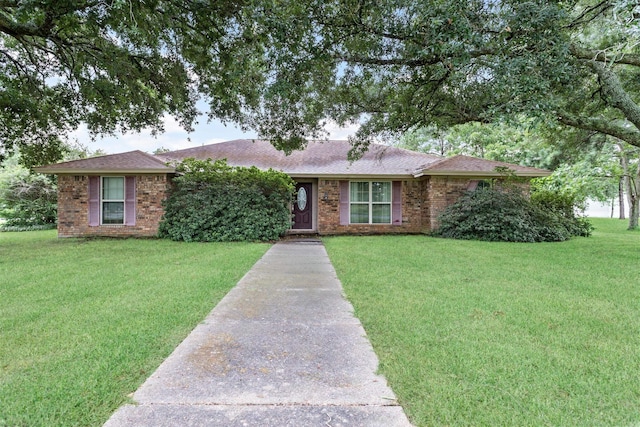 ranch-style house featuring brick siding and a front lawn