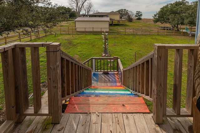 wooden terrace featuring a rural view and a lawn