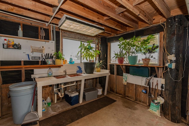 misc room with a workshop area, concrete floors, and sink