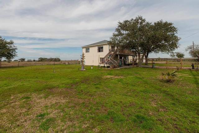 view of yard with a rural view and a deck