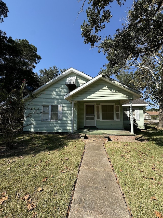 bungalow-style house featuring a porch and a front lawn