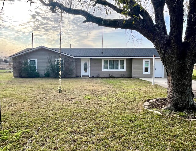 single story home featuring a garage and a front lawn