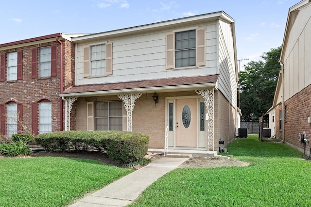 multi unit property featuring roof with shingles, central AC unit, a front lawn, and brick siding