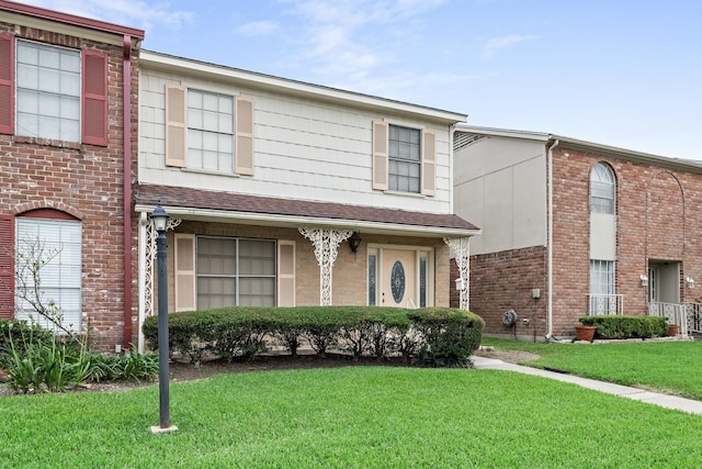 multi unit property featuring a front lawn and brick siding