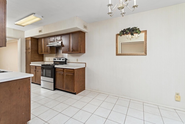 kitchen with visible vents, electric range, light countertops, under cabinet range hood, and a notable chandelier