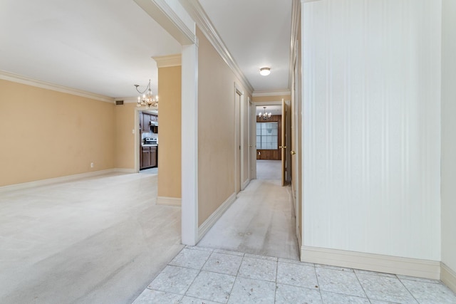 hallway with crown molding, light colored carpet, baseboards, and a chandelier