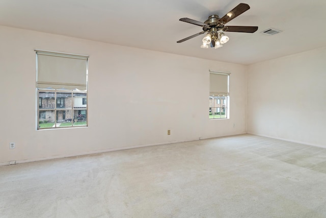 empty room featuring visible vents, carpet, ceiling fan, and baseboards