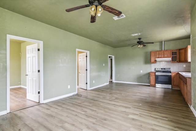 kitchen with stainless steel electric range, a ceiling fan, wood finished floors, brown cabinets, and under cabinet range hood