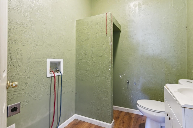bathroom featuring wood finished floors, toilet, and vanity