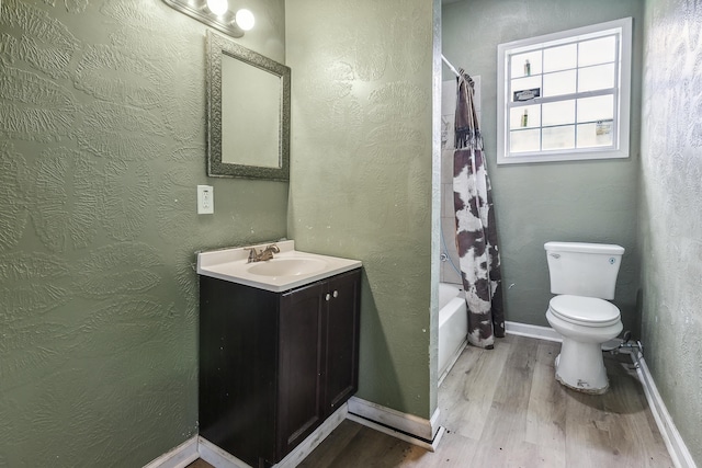 bathroom with shower / bath combo, wood finished floors, toilet, and vanity