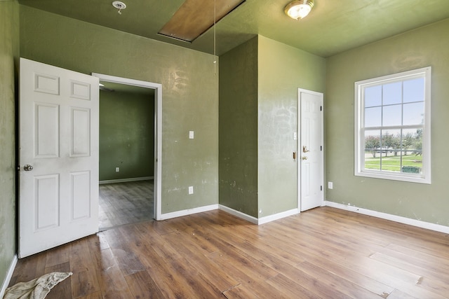 interior space with attic access, baseboards, and wood finished floors