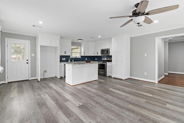 125 Needles, Vidor, TX 77662 - kitchen with appliances with stainless steel finishes, white cabinetry, crown molding, a ceiling fan, and backsplash