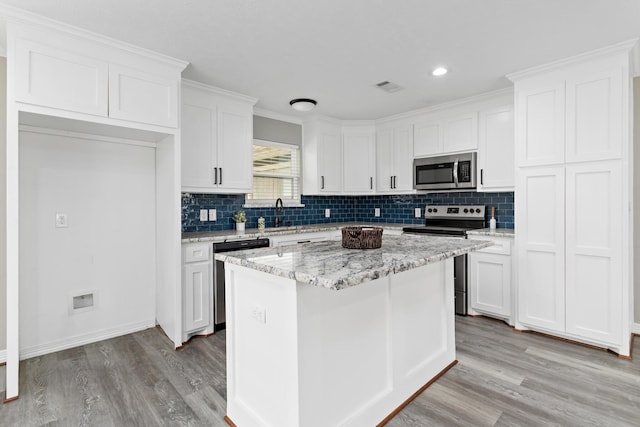 125 Needles, Vidor, TX 77662 - kitchen featuring stainless steel appliances, light wood-style flooring, white cabinets, backsplash, and recessed lighting