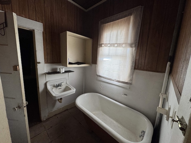 bathroom with tile patterned floors, a tub, and sink
