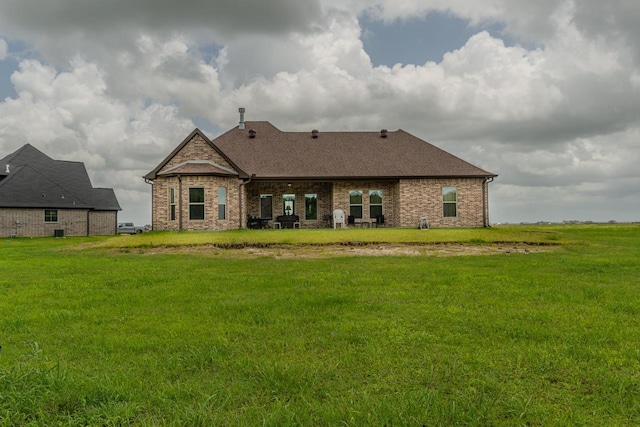 15360 Hercules Dr, Beaumont, TX 77713 - back of property featuring a lawn, brick siding, and a shingled roof