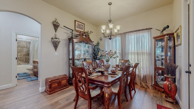 15360 Hercules Dr, Beaumont, TX 77713 - dining room featuring a chandelier, arched walkways, and light wood-type flooring