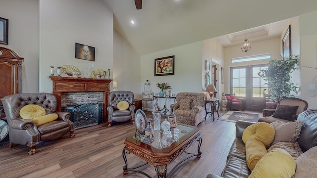 15360 Hercules Dr, Beaumont, TX 77713 - living room featuring wood finished floors, a brick fireplace, a towering ceiling, recessed lighting, and french doors
