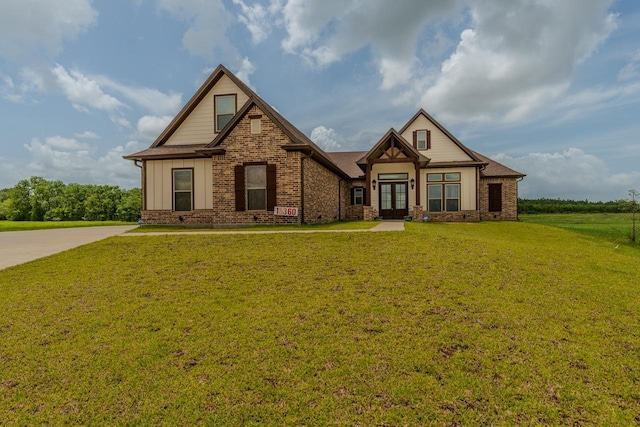15360 Hercules Dr, Beaumont, TX 77713 - craftsman house featuring french doors, a front lawn, board and batten siding, and brick siding
