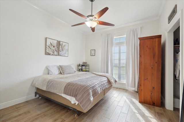 bedroom with crown molding, light hardwood / wood-style floors, and ceiling fan