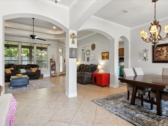 dining room featuring ceiling fan with notable chandelier, light tile patterned flooring, and crown molding