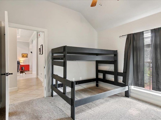 tiled bedroom with ceiling fan and vaulted ceiling