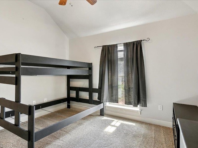 unfurnished bedroom featuring multiple windows, ceiling fan, carpet, and vaulted ceiling