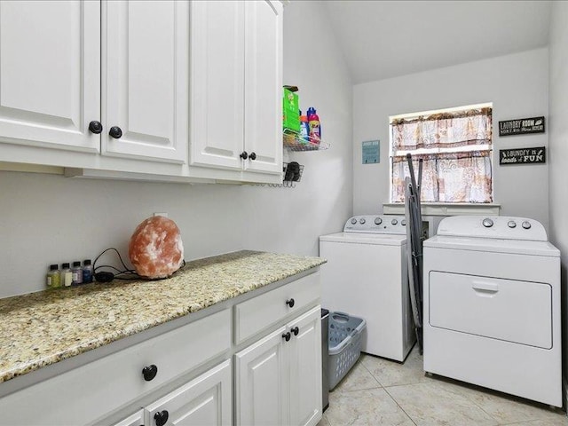 clothes washing area featuring cabinets, separate washer and dryer, and light tile patterned floors