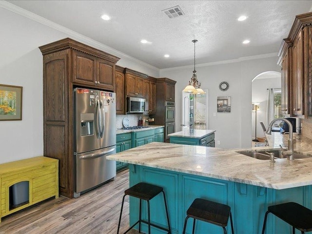 kitchen with appliances with stainless steel finishes, tasteful backsplash, crown molding, and sink