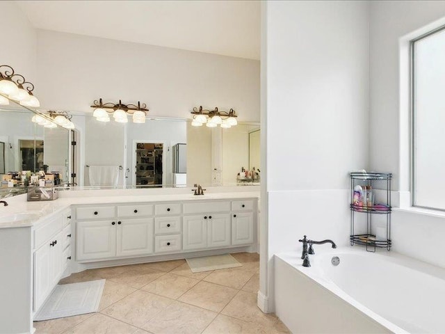 bathroom featuring tile patterned flooring, vanity, and a bath